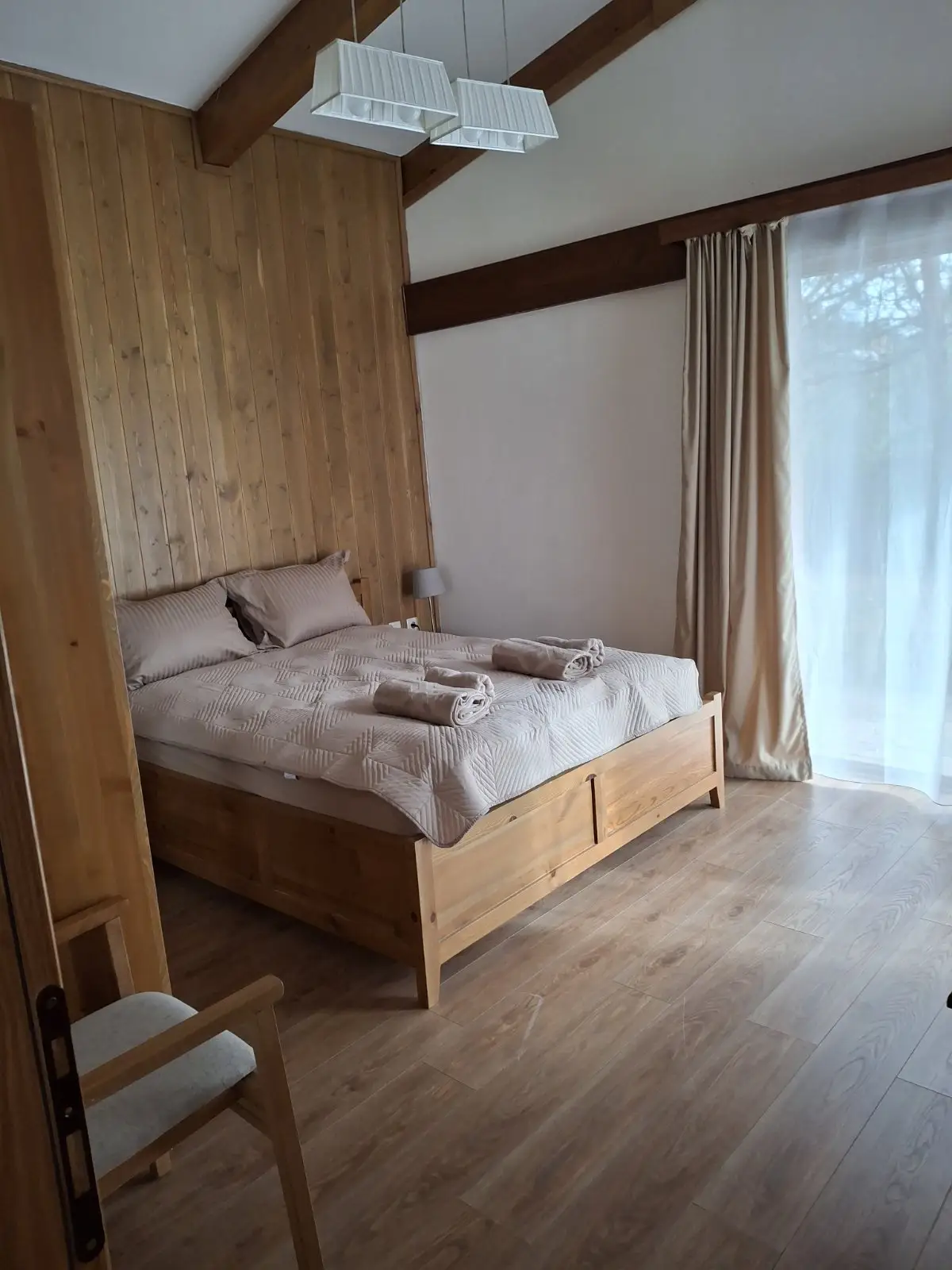 Spacious bedroom with a double bed and natural wood design.